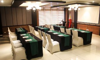 a conference room set up for a meeting , with multiple tables and chairs arranged in rows at Brentwood Suites