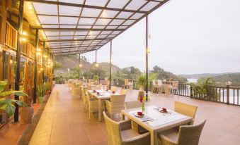 an outdoor dining area with several tables and chairs set up for guests to enjoy a meal at Phong Nha Lake House Resort