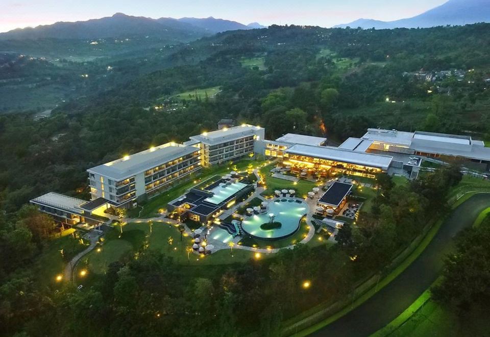 an aerial view of a large resort with multiple buildings , a pool , and lush greenery at Royal Tulip Golf Resort Gunung Geulis