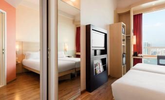a bedroom with two beds and an open doorway leading to the restroom at ibis Hong Kong Central and Sheung Wan Hotel