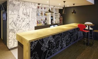 a bar counter with a black and white patterned surface , surrounded by various items and decorations at Ibis London Greenwich