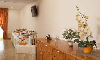 a room with a buffet table filled with various food items , including fruits , vegetables , and desserts at City Hotel