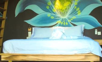 a bedroom with a large blue and white floral mural on the wall , creating a vibrant atmosphere at The Happy 8 Retreat @ Kuala Sepetang