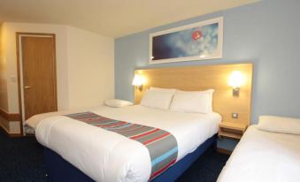 a hotel room with two beds , one on the left and one on the right side of the room at Travelodge Ludlow Woofferton