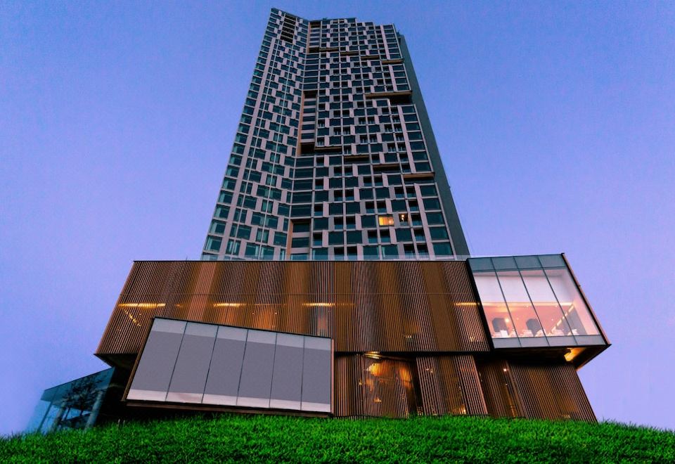 a tall building with a unique design , possibly a tower or a skyscraper , situated in a city at Arize Hotel Sri Racha