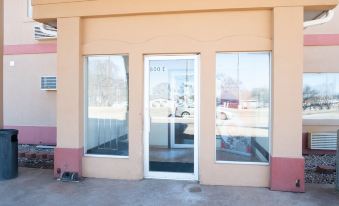 a large , empty building with a glass door and three windows , providing ample natural light at Executive Inn