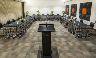 a conference room set up for a meeting , with rows of chairs arranged in a semicircle around a podium at The Pearl South Pacific Resort