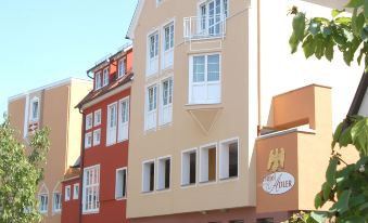 "a multi - story building with a sign that says "" h "" on it , located in a residential area" at Hotel Adler - Paulas Alb