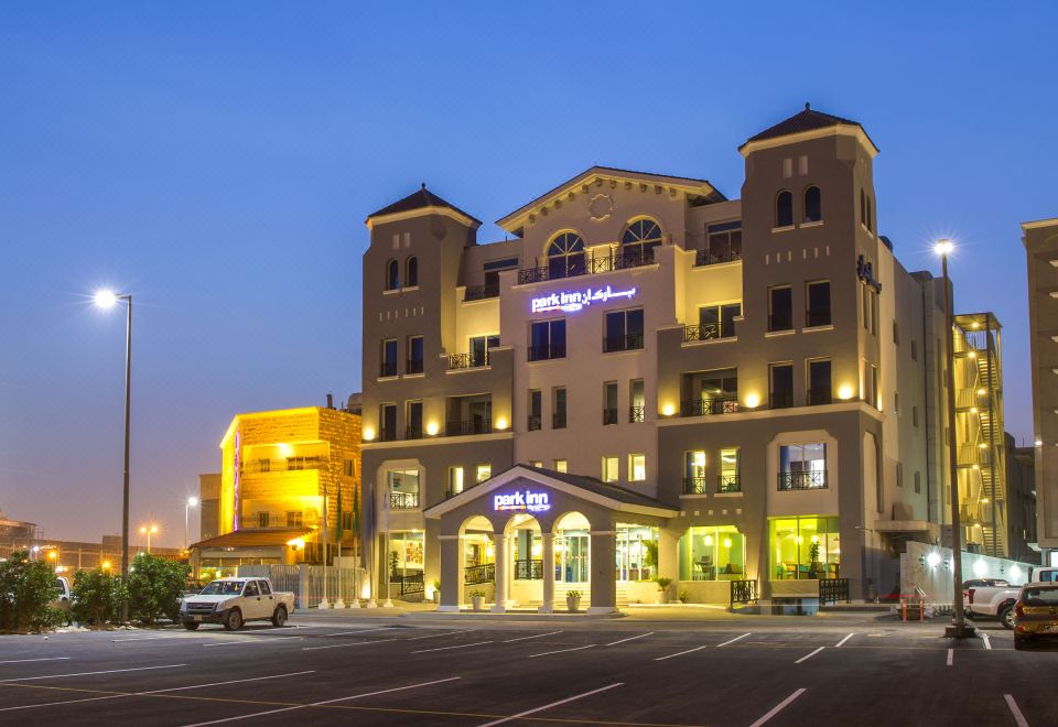 "a large building with a sign that says "" niagara "" is lit up at night , and a parking lot in front of it" at Park Inn by Radisson Dammam