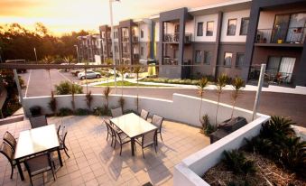 a modern apartment building with a balcony and outdoor dining area , providing a comfortable and inviting atmosphere for residents at Quest Ipswich