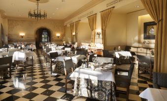a large dining room with numerous tables and chairs arranged for a group of people to enjoy a meal together at Parador de Leon - San Marcos