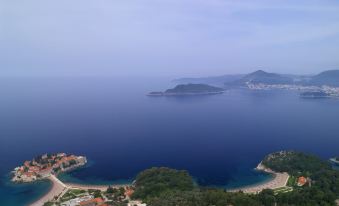 a scenic view of a large body of water with two small islands in the distance at Aman Sveti Stefan