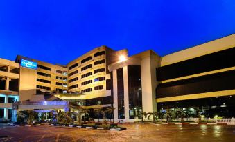 a large building with a parking lot in front of it , illuminated by street lights at Chon Inter Hotel