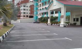 a large , empty parking lot with a white line down the middle and buildings on either side at Marina Island Pangkor Resort & Hotel