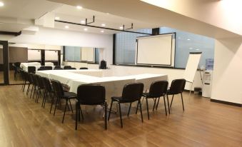 a large conference room with multiple chairs arranged in a semicircle around a long table at Hamra Urban Gardens