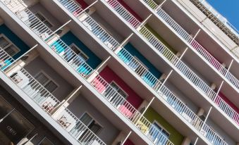 a modern apartment building with multiple balconies and white railings , giving it a unique and colorful appearance at Artiem Capri