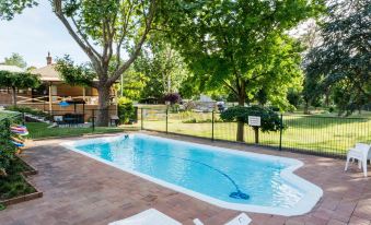 a backyard with a swimming pool surrounded by trees , creating a serene and inviting atmosphere at Berrima Bakehouse Motel