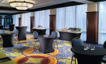 a conference room with multiple tables and chairs arranged for a meeting or event at Atlanta Airport Marriott