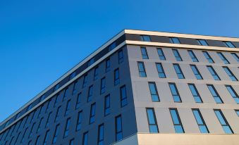 a modern building with multiple windows and a clear blue sky in the background , providing a sense of urban life at Radisson Blu Hotel and Conference Cente, Oslo Alna
