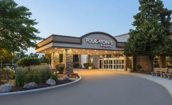 an exterior view of a four points by sheraton hotel , with a large building visible in the background at Four Points by Sheraton Chicago O'Hare