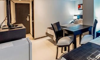 a modern hotel room with a bed , desk , and other furniture , including a bed , desk , chair , and kitchenette at Hotel Metropolitano
