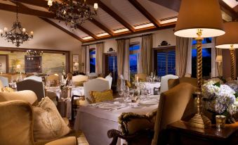 a lavish dining room with a table set for a formal dinner , surrounded by elegant furniture and decorations at Rosewood Bermuda