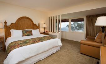 a large bed with a wooden headboard is in a room with a window and a chair at Volcano House