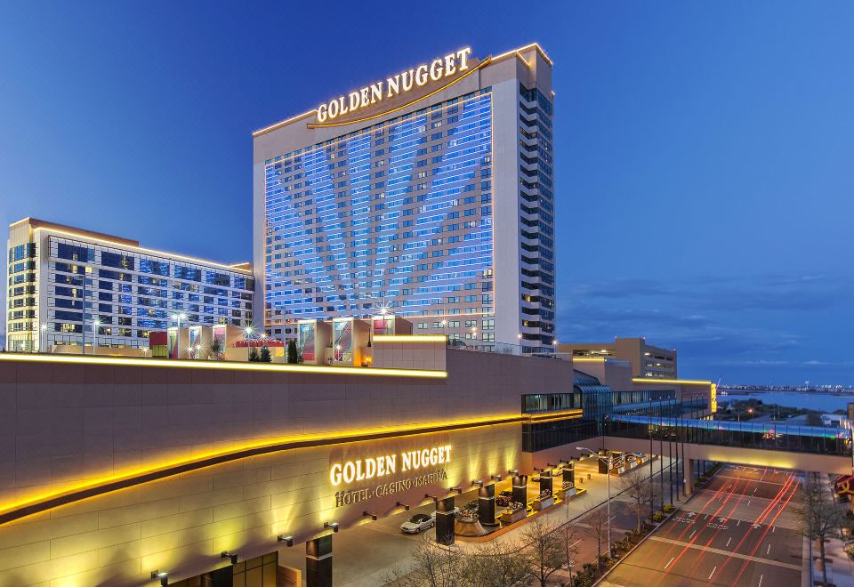 "a large building with a blue sky in the background , and the words "" golden nugget "" are illuminated above it" at Golden Nugget