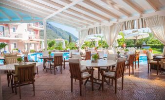 an outdoor dining area with several tables and chairs arranged around a pool , providing a pleasant atmosphere for guests at G George