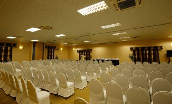 an empty conference room with rows of white chairs arranged neatly , ready for a meeting or event at Maun Lodge