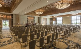 a large , empty conference room with rows of chairs and chandeliers hanging from the ceiling at Four Seasons Hotel Tunis