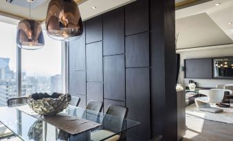 a dining room with a glass table and chairs , surrounded by a black wall with a television mounted on it at Icon Hotel