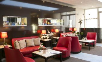a modern , well - lit restaurant with red and white couches , chairs , tables , and potted plants on the walls at Mercure Chartres Cathedrale