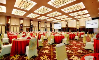a large banquet hall with numerous tables and chairs arranged for a formal event , possibly a wedding or conference at ASTON Purwokerto Hotel & Convention Center