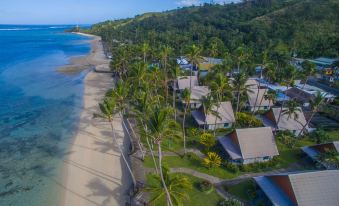 aerial view of a tropical beach resort surrounded by palm trees and a sandy beach at Fiji Hideaway Resort and Spa