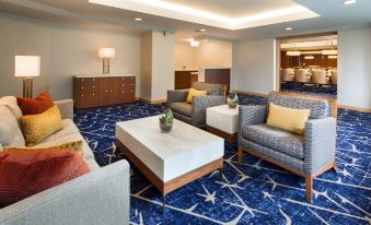 a modern hotel lobby with blue carpeting , white furniture , and a large window providing natural light at Sheraton Grand Seattle