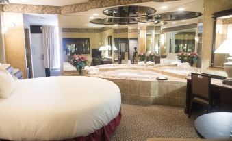 a large , round bed is in the middle of a room with a mirror on the wall and other furniture at Paradise Stream Resort