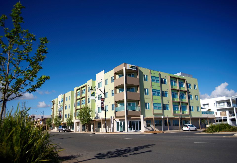 a large , modern apartment building with multiple floors and balconies , situated on a sunny day at Quest Mawson Lakes