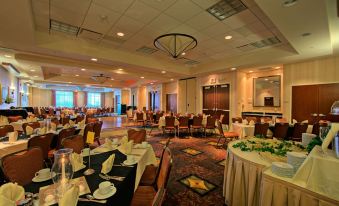 a large , well - lit banquet hall with multiple tables and chairs set up for a formal event at Hilton Garden Inn Laramie