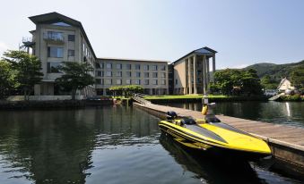 a yellow speedboat is docked at a marina with a building in the background at Hakone Hotel
