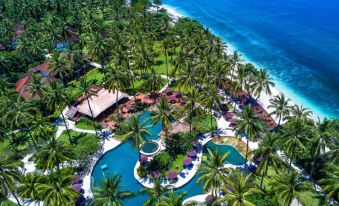 aerial view of a tropical resort with a pool surrounded by palm trees and lush greenery at Holiday Resort Lombok