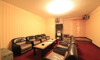 a cozy living room with several couches and chairs arranged in a comfortable seating area at Hotel Mahoroba