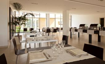 a large dining room with several tables and chairs , some of which are set up for a formal event at Inn Naples Airport