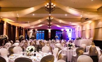 a large banquet hall with multiple tables set for a formal event , featuring white tablecloths and elegant decorations at Hotel Bellinzona Daylesford