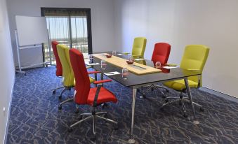 a conference room with a large table surrounded by several chairs , and a window in the background at Rydges Palmerston - Darwin, an EVT hotel