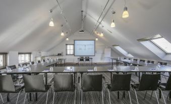 a large conference room with multiple rows of chairs arranged in a semicircle around a long table at Fletcher Hotel - Restaurant Nautisch Kwartier