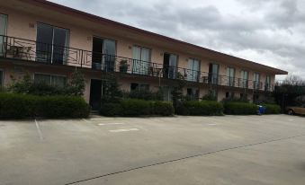 a large building with balconies and a parking lot in front of it , under a cloudy sky at Crest Motor Inn