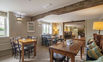 a dining room with wooden tables and chairs arranged for a group of people to enjoy a meal together at Wild Thyme & Honey