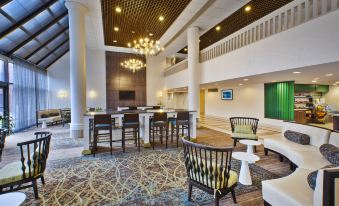 a spacious hotel lobby with high ceilings , a large chandelier , and various seating areas for guests at Holiday Inn Washington-Dulles International Airport, an IHG Hotel