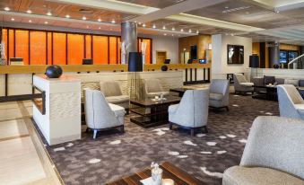 a modern lounge area with comfortable seating , a coffee table , and an orange wall panel at Vienna Marriott Hotel